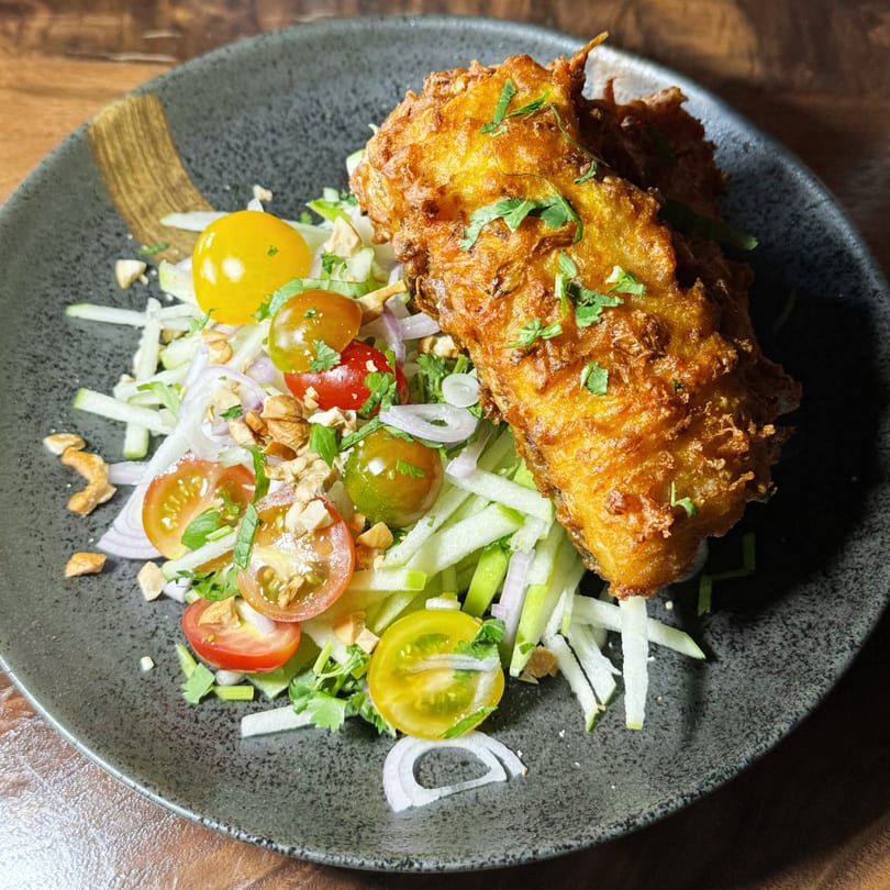 Crispy fried fish with a fresh Thai salad of cherry tomatoes, onions, and green apple.